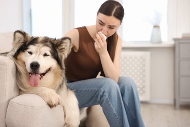 Photo of Woman suffering from allergy with her dog at home