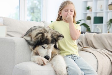 Photo of Girl suffering from allergy with her dog at home