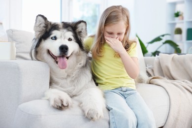Photo of Girl suffering from allergy with her dog at home