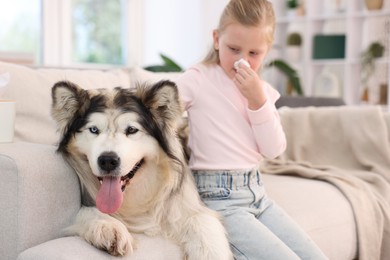 Photo of Girl suffering from allergy with her dog at home