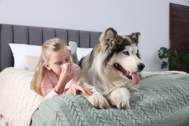 Photo of Girl suffering from allergy with her dog on bed at home