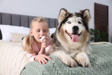 Photo of Girl suffering from allergy with her dog on bed at home