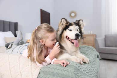 Photo of Girl suffering from allergy with her dog on bed at home
