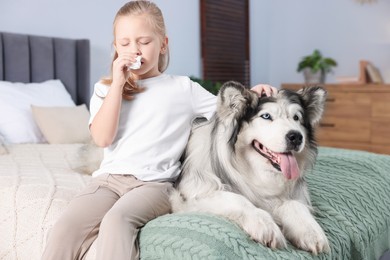 Photo of Girl suffering from allergy with her dog on bed at home