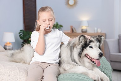 Photo of Girl suffering from allergy with her dog on bed at home