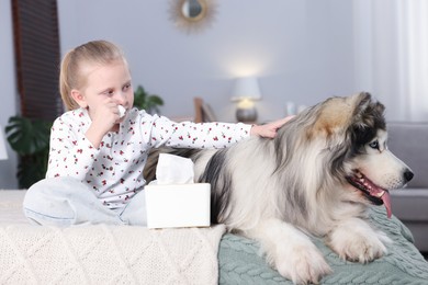 Photo of Girl suffering from allergy with her dog on bed at home