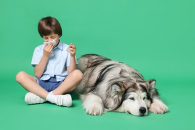 Photo of Boy suffering from allergy with her dog on green background. Space for text
