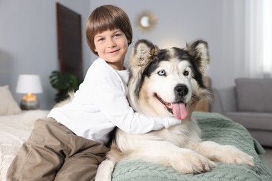 Photo of Happy boy and cute dog on bed at home