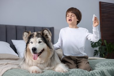 Photo of Boy suffering from allergy with her dog on bed at home