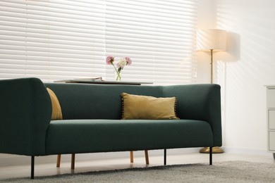 Photo of Stylish living room with cozy sofa and white wall. Interior design