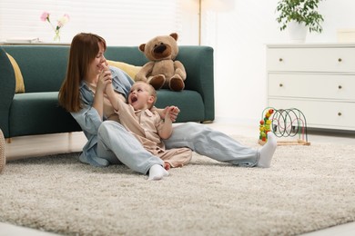 Photo of Happy mother spending time together with her son on floor at home