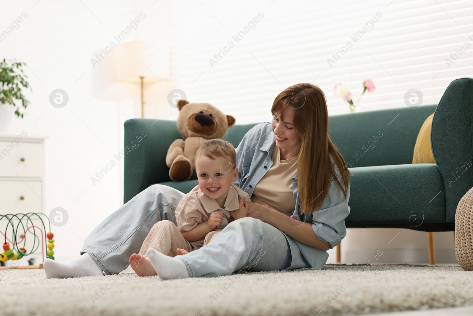 Happy mother spending time together with her son on floor at home Photo of Happy mother spending time together with her son on floor at home