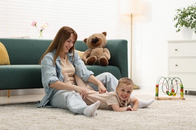 Photo of Happy mother spending time together with her son on floor at home
