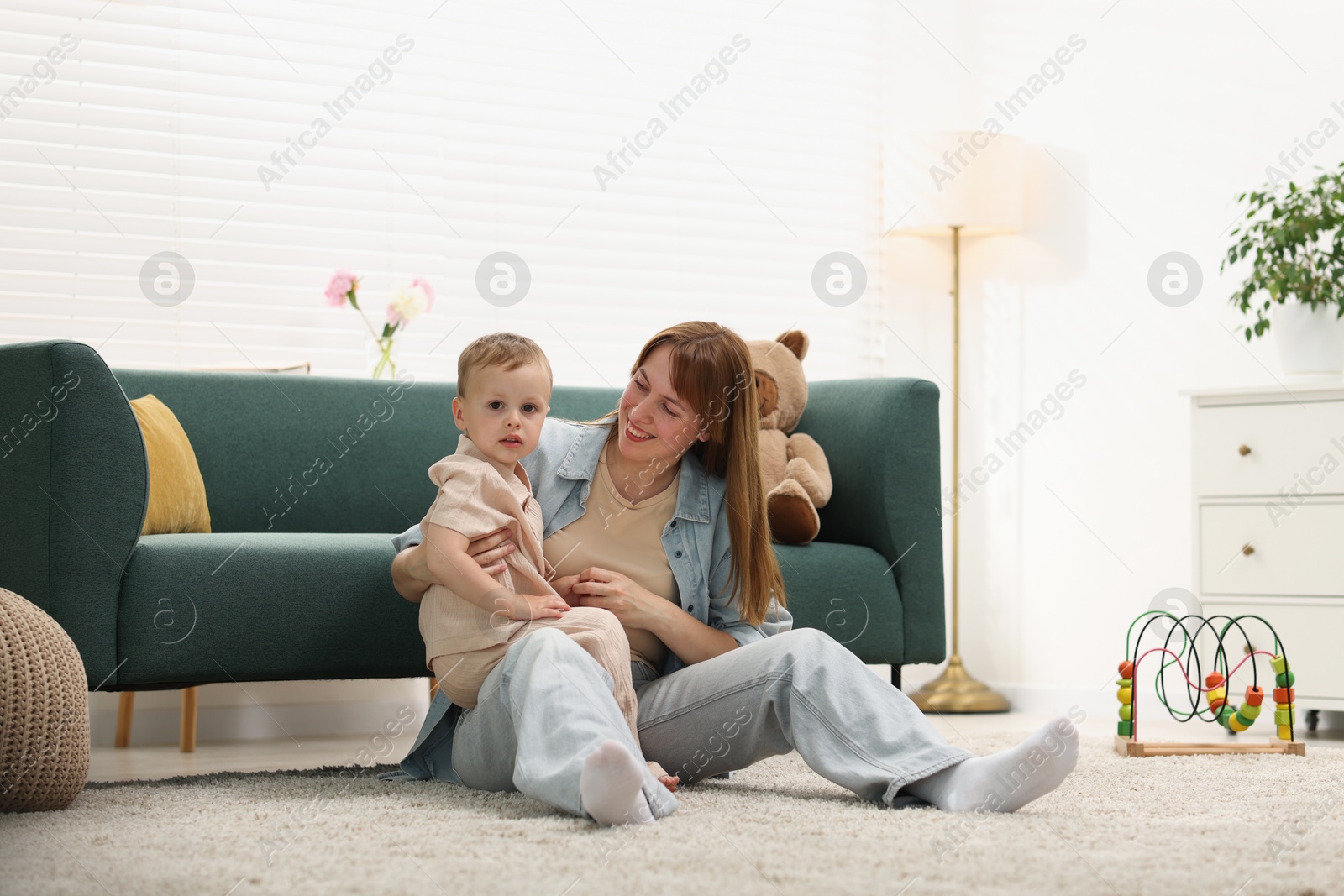 Happy mother spending time together with her son on floor at home Photo of Happy mother spending time together with her son on floor at home