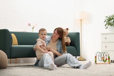 Photo of Happy mother spending time together with her son on floor at home