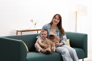 Photo of Happy mother with her son on sofa at home
