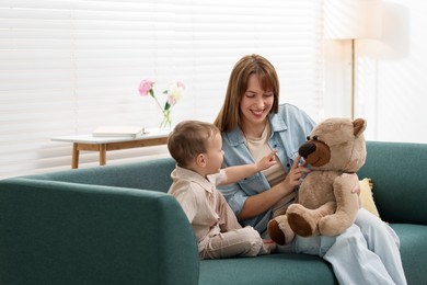 Photo of Happy mother with her son on sofa at home