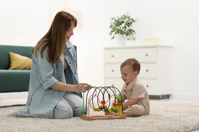 Photo of Happy mother playing with her son on floor at home