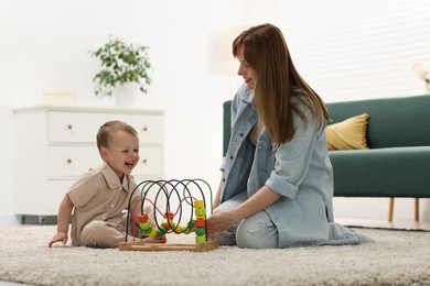 Photo of Happy mother playing with her son on floor at home