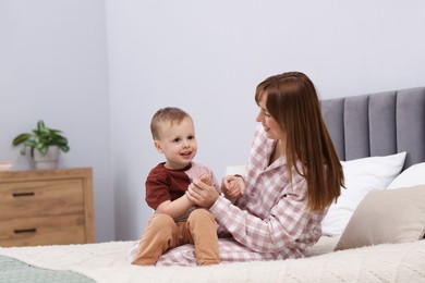 Photo of Happy mother spending time together with her son on bed at home
