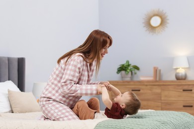 Photo of Happy mother spending time together with her son on bed at home