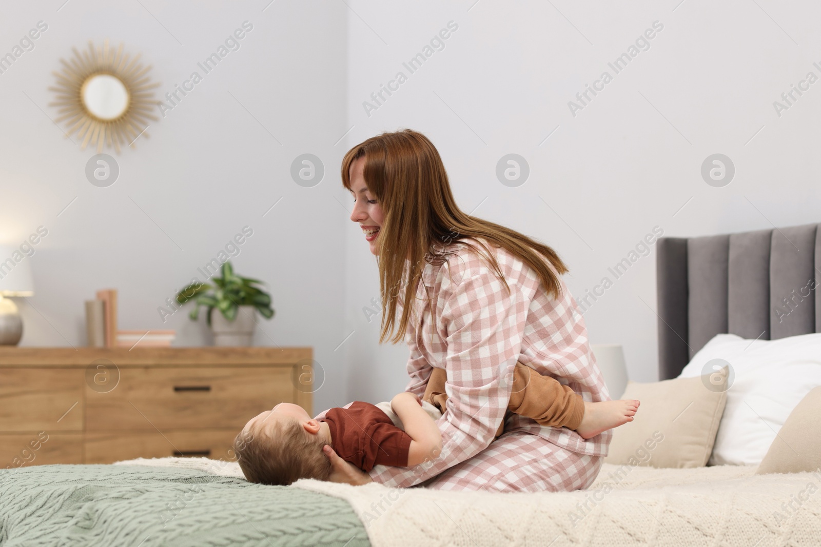 Happy mother spending time together with her son on bed at home Photo of Happy mother spending time together with her son on bed at home