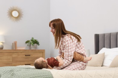Photo of Happy mother spending time together with her son on bed at home