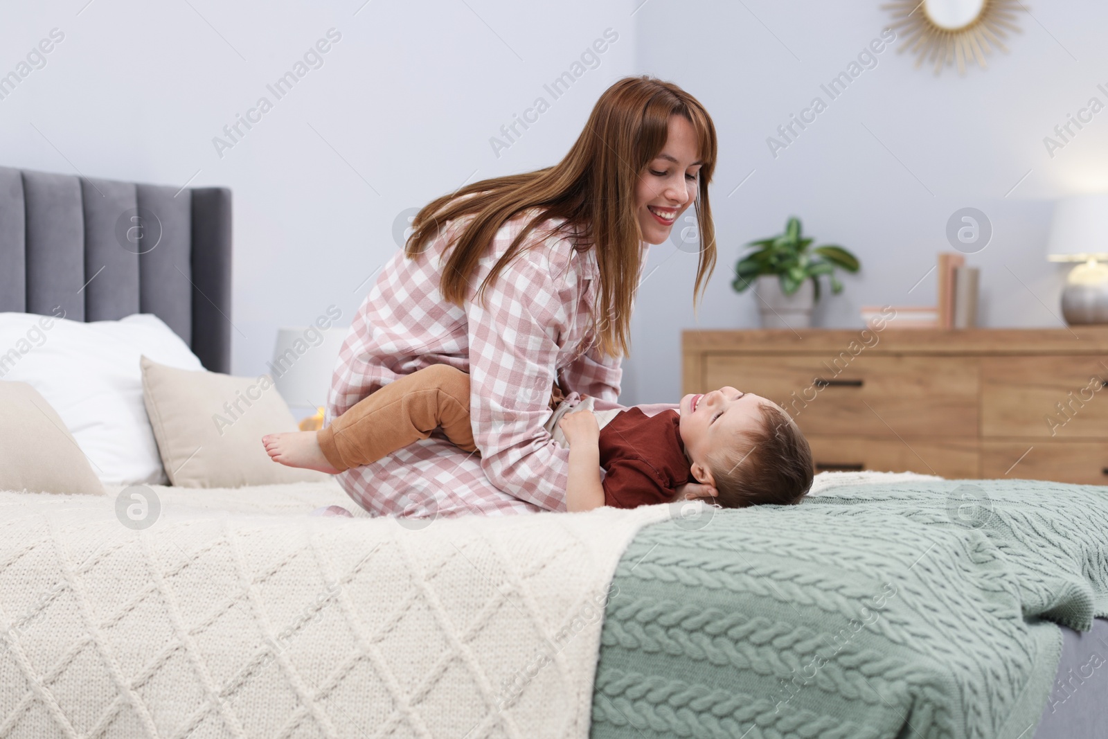 Happy mother spending time together with her son on bed at home Photo of Happy mother spending time together with her son on bed at home