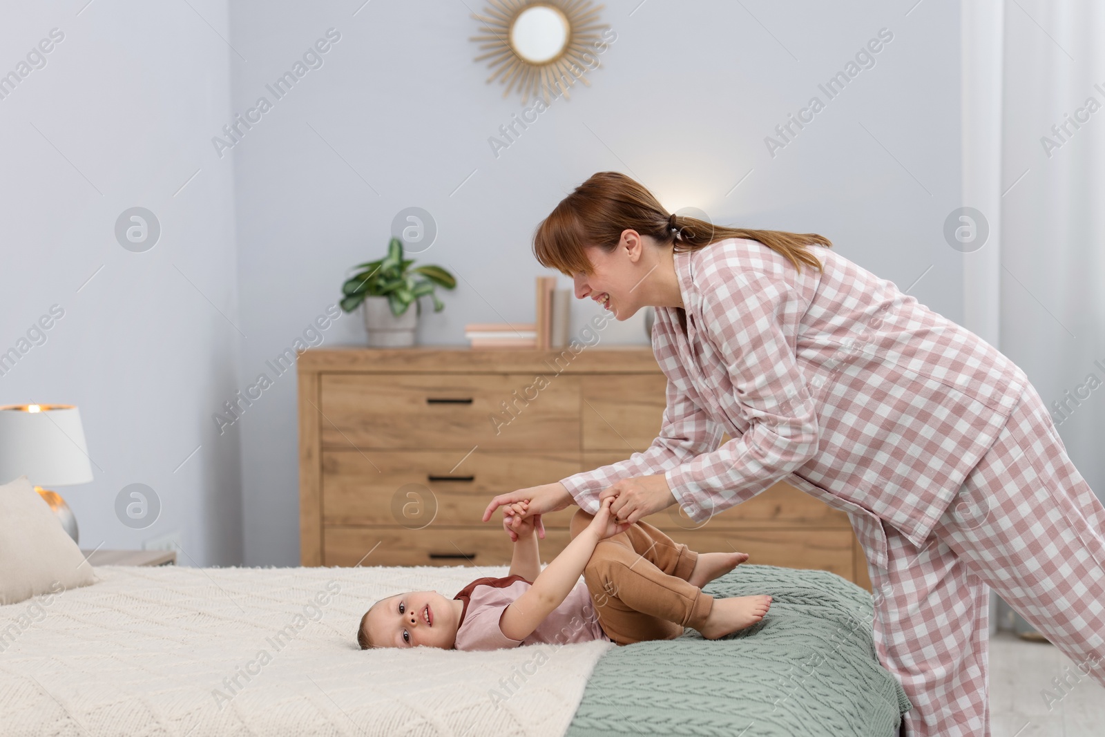 Happy mother spending time together with her son on bed at home Photo of Happy mother spending time together with her son on bed at home