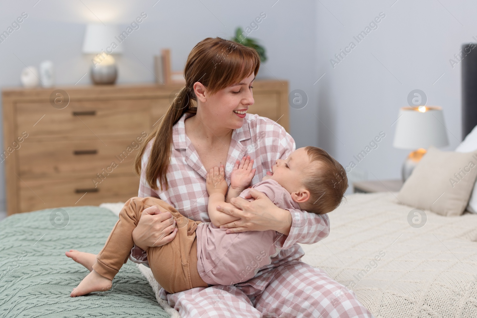 Happy mother spending time together with her son on bed at home Photo of Happy mother spending time together with her son on bed at home