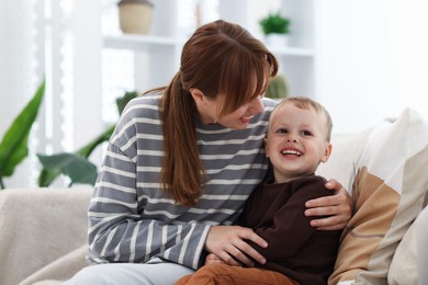 Photo of Happy mother spending time together with her son on sofa at home