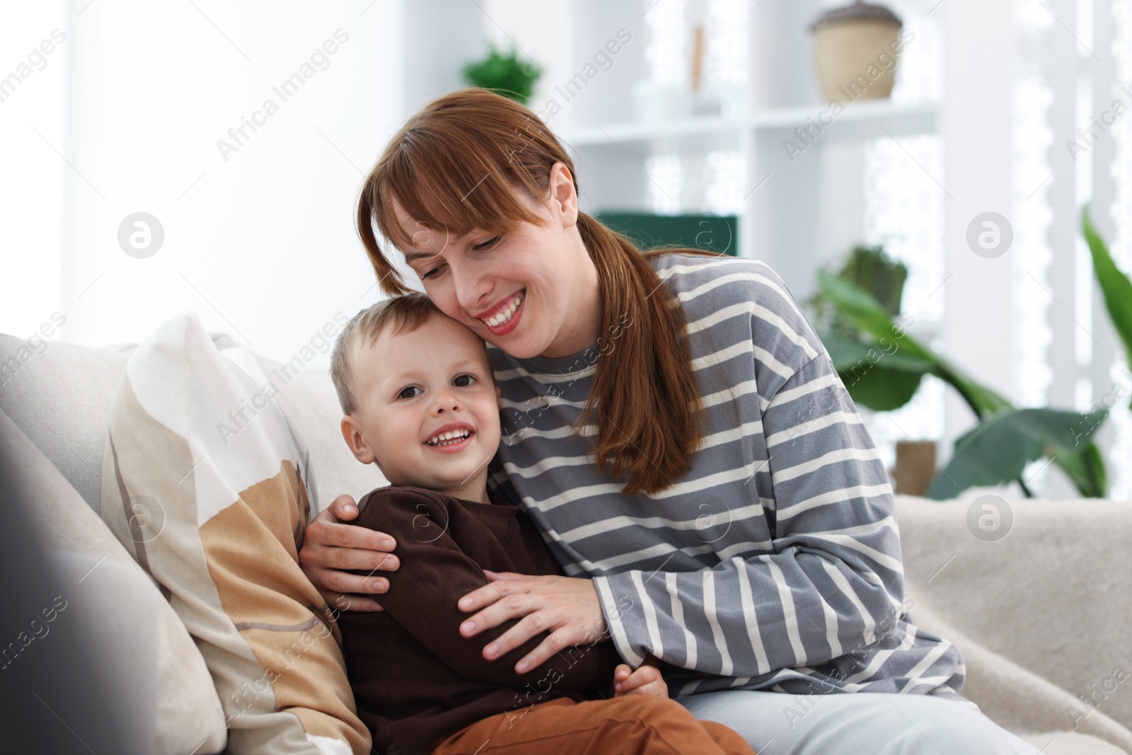 Happy mother spending time together with her son on sofa at home Photo of Happy mother spending time together with her son on sofa at home