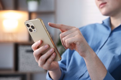Photo of Woman using modern smartphone at home, closeup