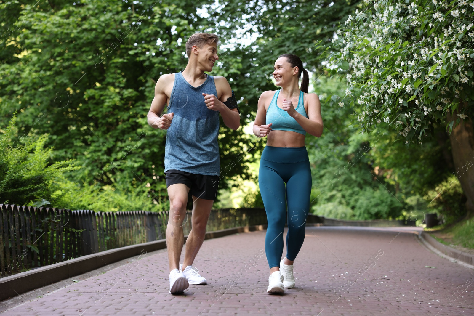 Sporty couple running in park. Healthy lifestyle Photo of Sporty couple running in park. Healthy lifestyle