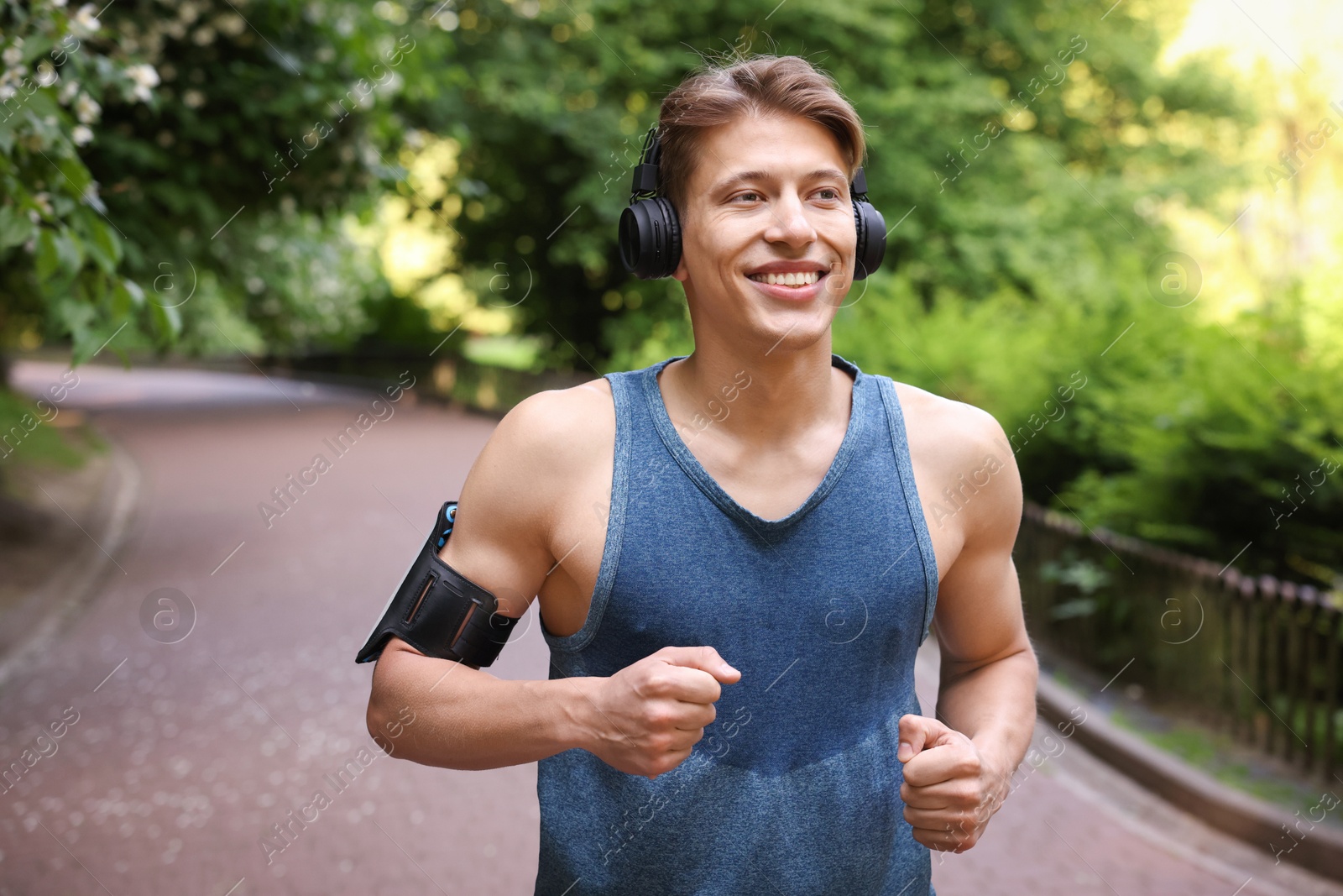 Sporty man with headphones running in park Photo of Sporty man with headphones running in park