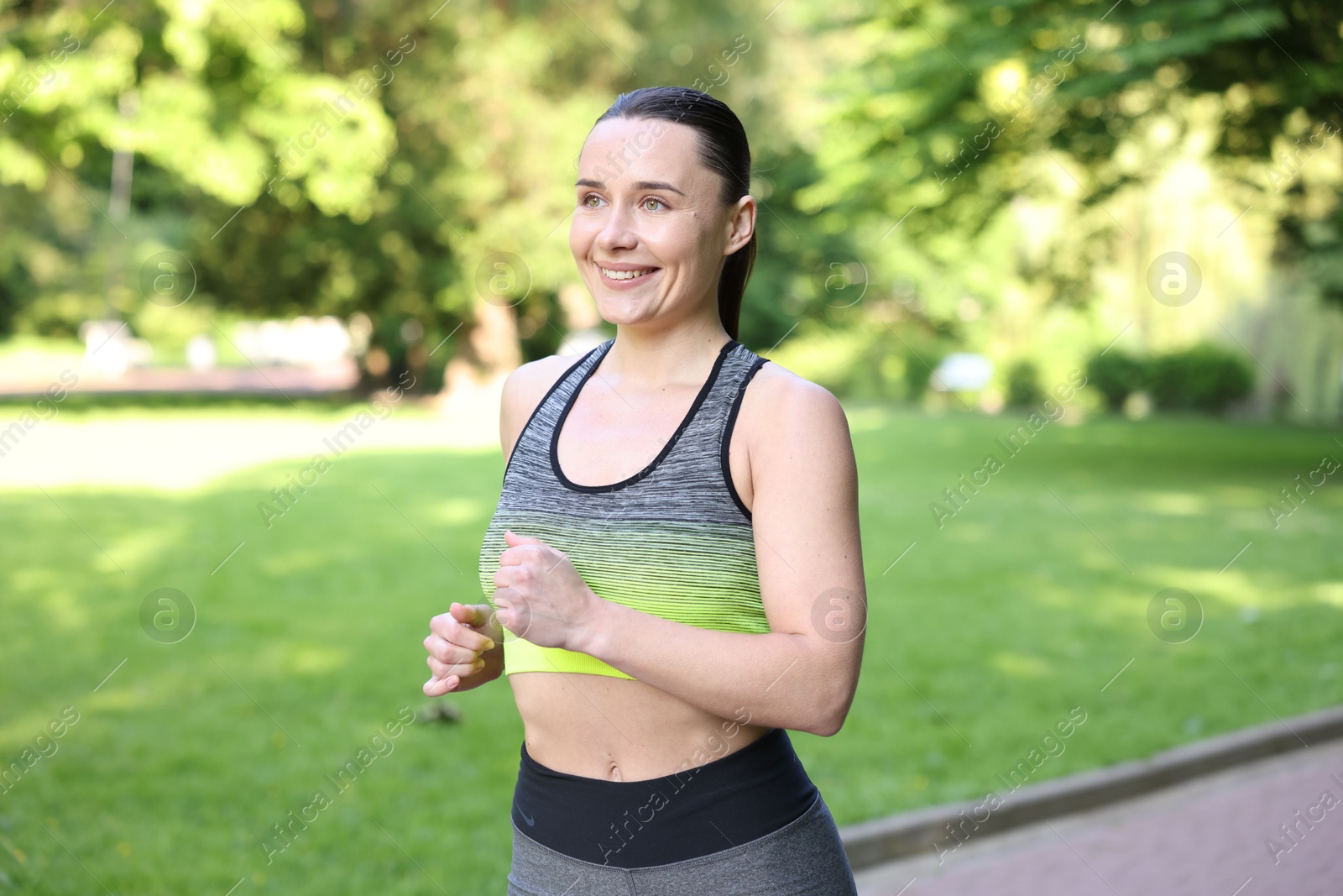 Sporty woman running in park. Healthy lifestyle Photo of Sporty woman running in park. Healthy lifestyle