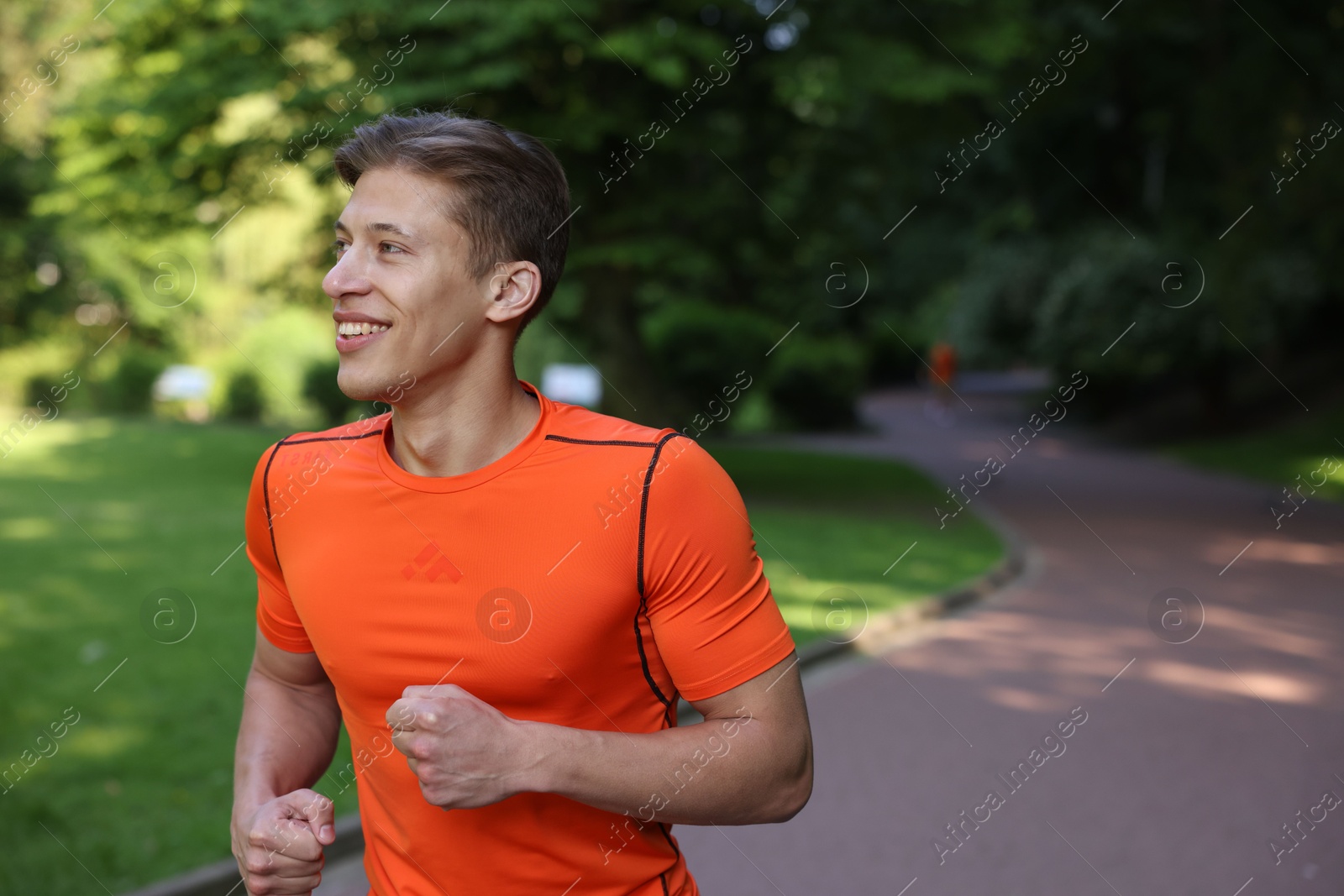 Sporty man running in park, space for text Photo of Sporty man running in park, space for text