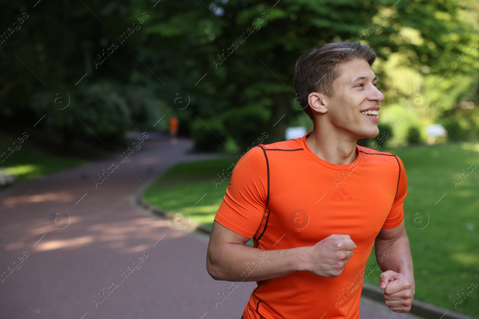 Sporty man running in park, space for text Photo of Sporty man running in park, space for text