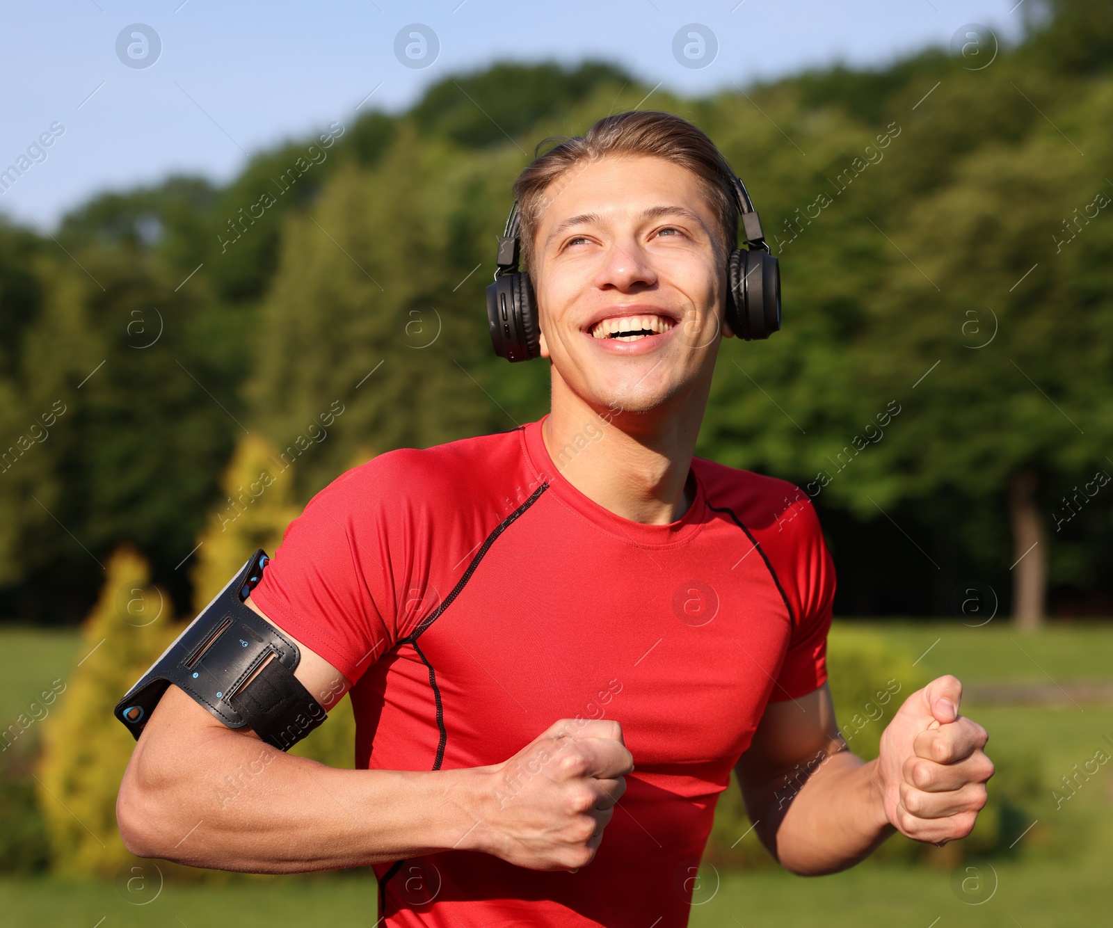 Sporty man with headphones running in park Photo of Sporty man with headphones running in park