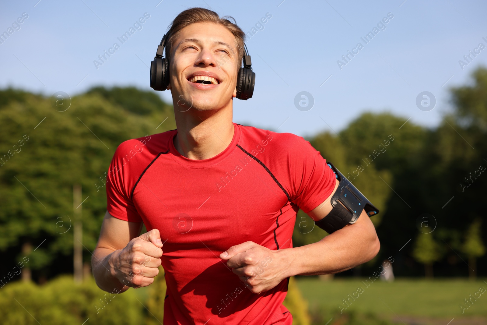 Sporty man with headphones running in park Photo of Sporty man with headphones running in park