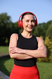 Photo of Happy woman in headphones outdoors. Healthy lifestyle