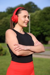 Photo of Happy woman in headphones outdoors. Healthy lifestyle
