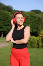 Photo of Happy woman in headphones outdoors. Healthy lifestyle