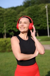 Photo of Happy woman in headphones outdoors. Healthy lifestyle