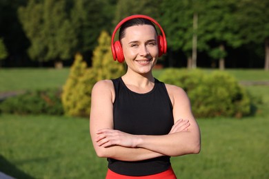 Photo of Happy woman in headphones outdoors. Healthy lifestyle