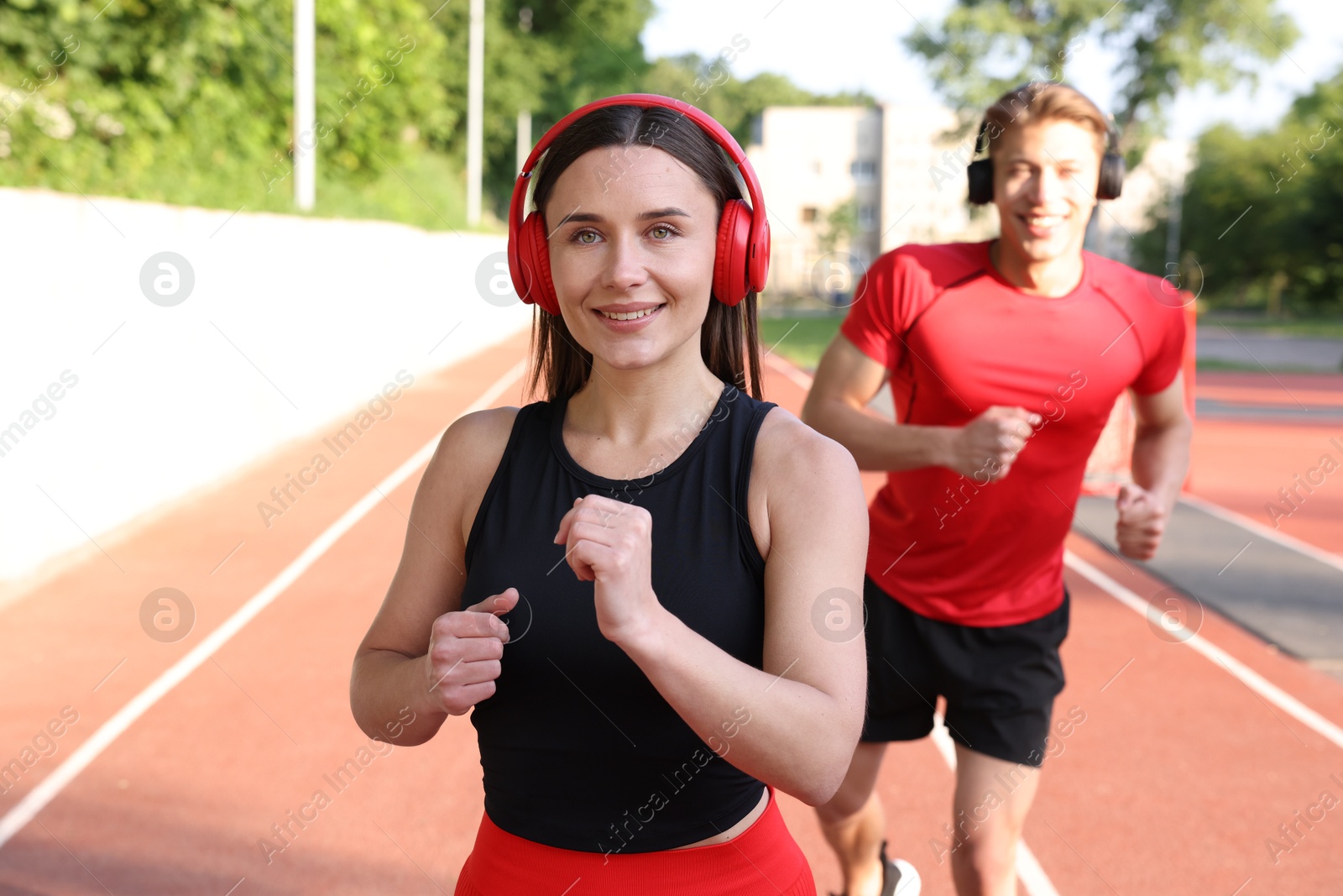 Sporty couple running at stadium, selective focus Photo of Sporty couple running at stadium, selective focus