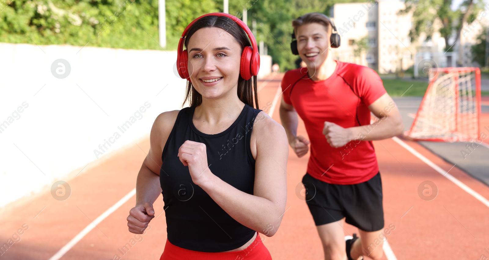 Sporty couple running at stadium, selective focus Photo of Sporty couple running at stadium, selective focus