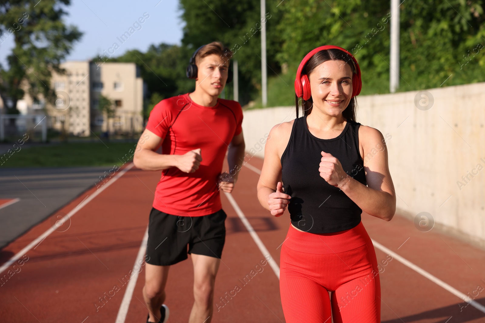 Sporty couple running at stadium. Healthy lifestyle Photo of Sporty couple running at stadium. Healthy lifestyle
