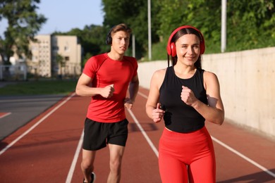 Photo of Sporty couple running at stadium. Healthy lifestyle