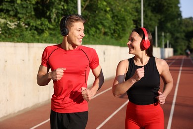 Photo of Sporty couple running at stadium. Healthy lifestyle